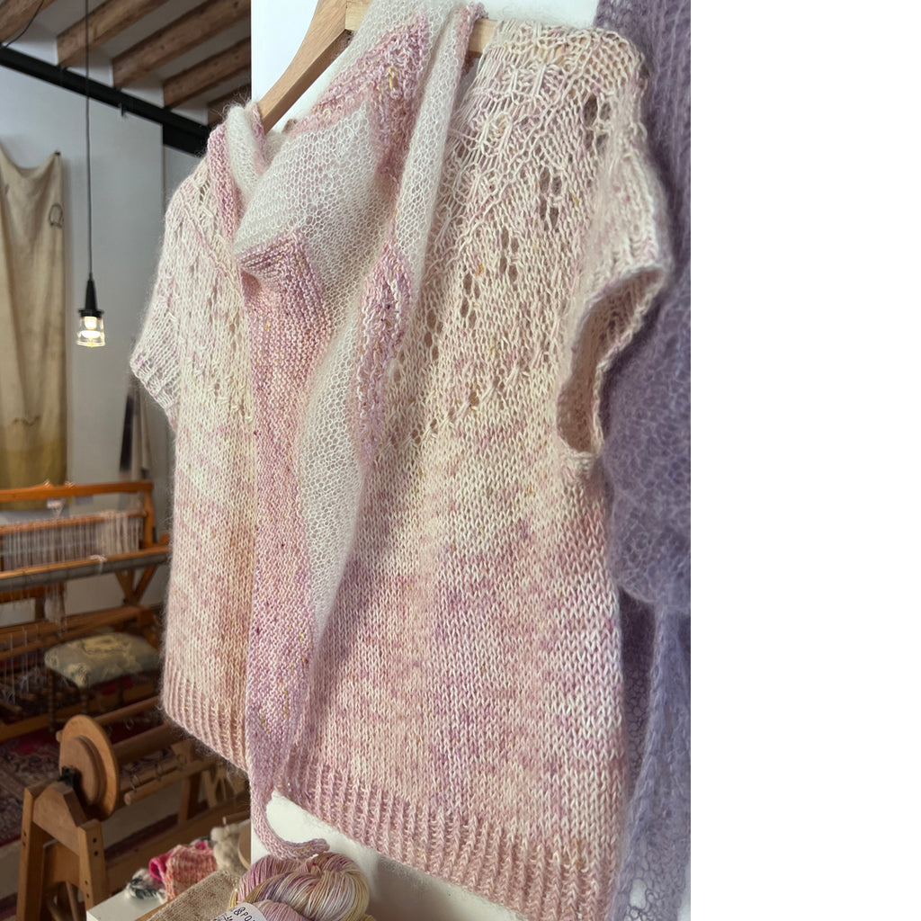 Short-sleeved knitted Ranunculus sweater in pink hanging on wall