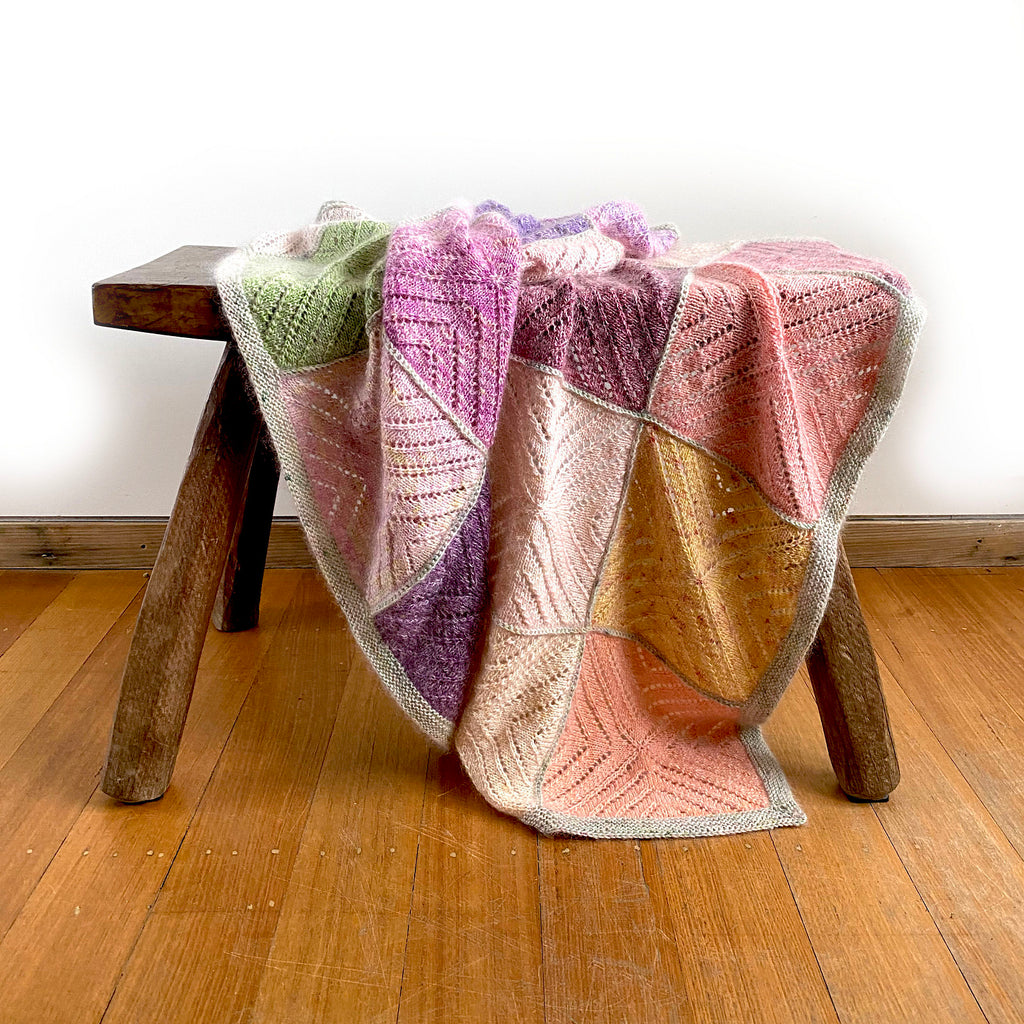 Radvent Throw knitted blanket by Ambah O'Brien draped on footstool