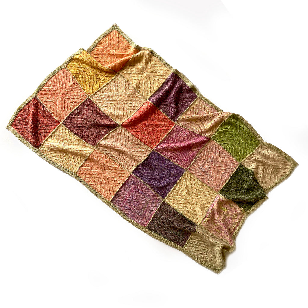 Radvent Throw knitted blanket by Ambah O'Brien laying flat on floor